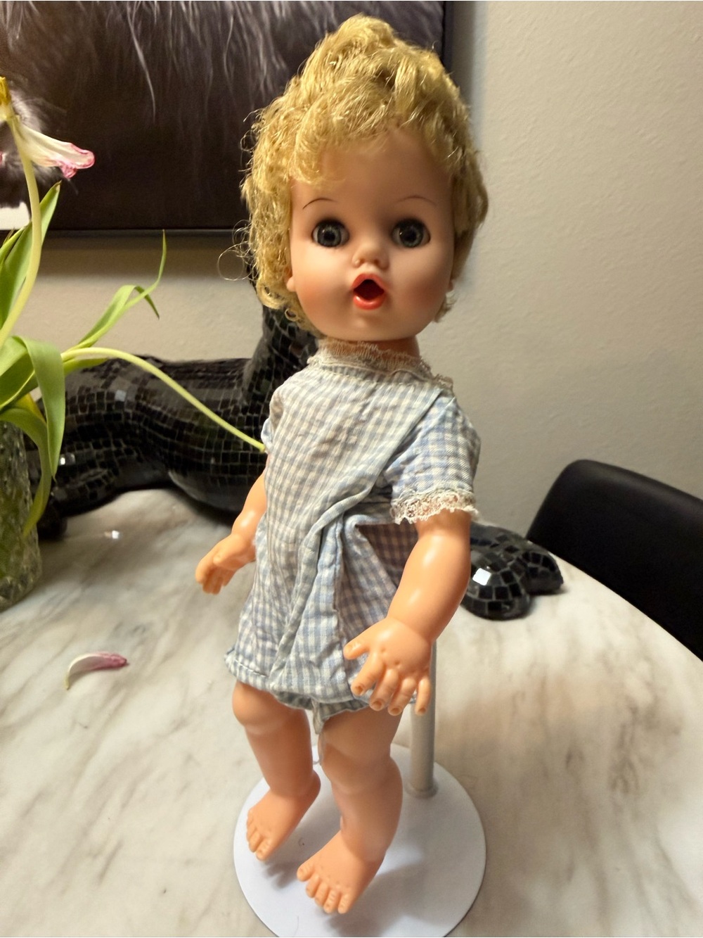 Antique baby doll in checkered outfit